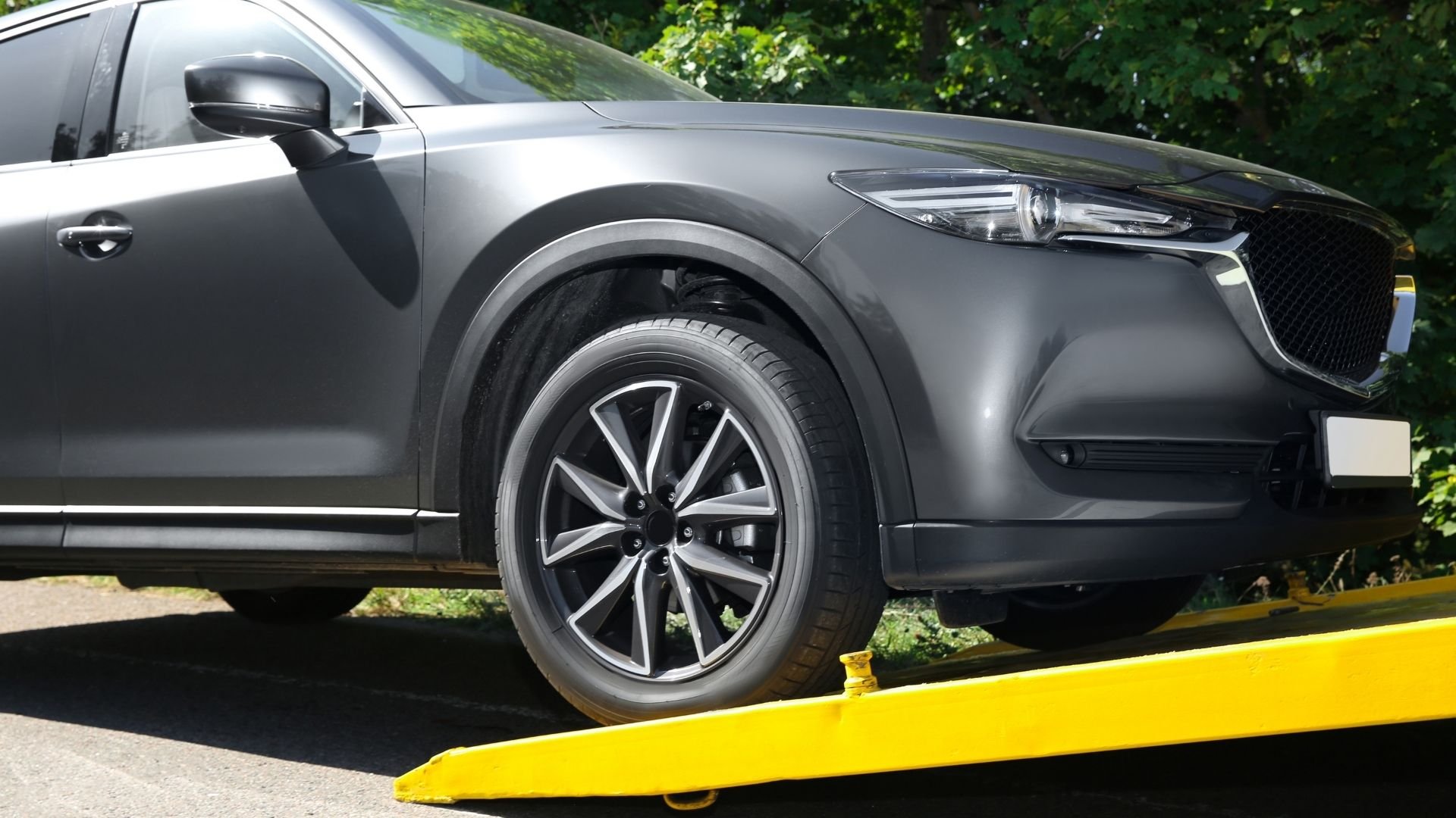 Gray SUV with stylish alloy wheel parked on yellow platform
